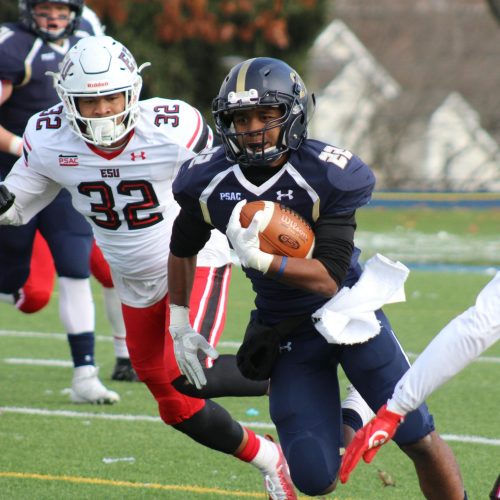 Dynamic college football match with players in action, showcasing athleticism and teamwork on the field.